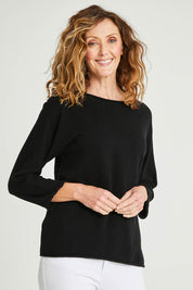 Model Emma wearing size 10 of the Knit Organic Cotton Top Long Sleeve in colour Black (Black), from the front, cropped image