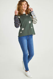 Model Emma wearing size 10 of the Knit Reversible Organic Cotton Jumper in colour Colour1 (Green), from the front, showing the whole outfit