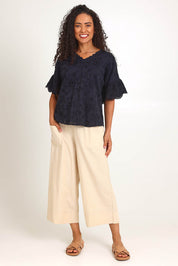Model Pamelar wearing size 10 of the Essentials Broderie Frill Sleeve Cotton Top - Black in colour Black, from the front