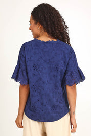 Model Pamelar wearing size 10 of the Essentials Broderie Frill Sleeve Cotton Top - Navy in colour Navy, from the back
