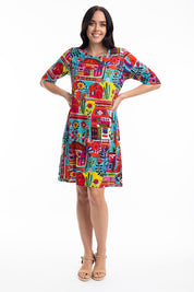 A model wearing the Contemporary Elbow Sleeve Dress in colour Folkhuts (Blue), from the front, showing the whole outfit
