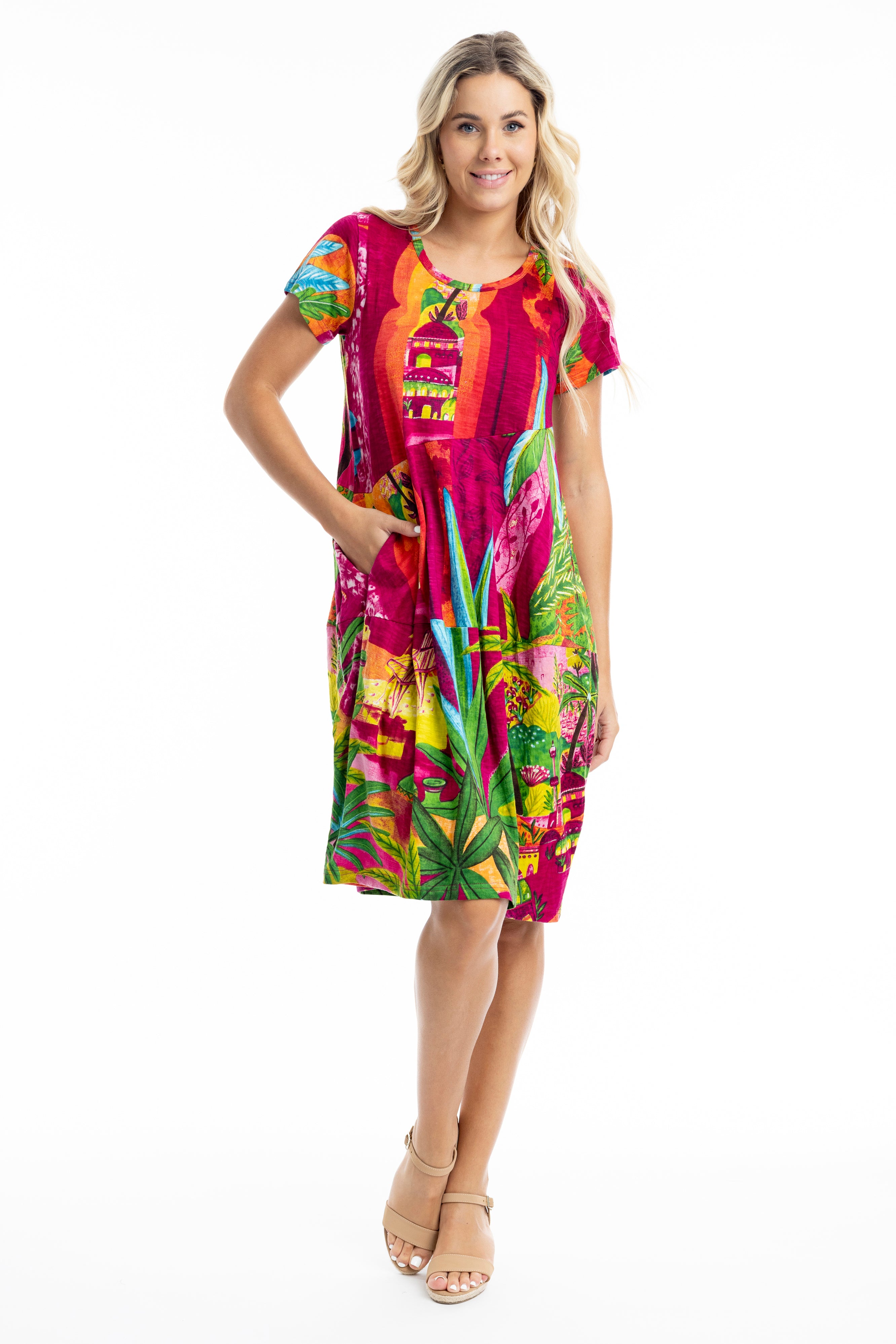 A model wearing the Printed Bubble Organic Cotton Dress in colour Marrakesh (Red), from the front, showing the whole outfit