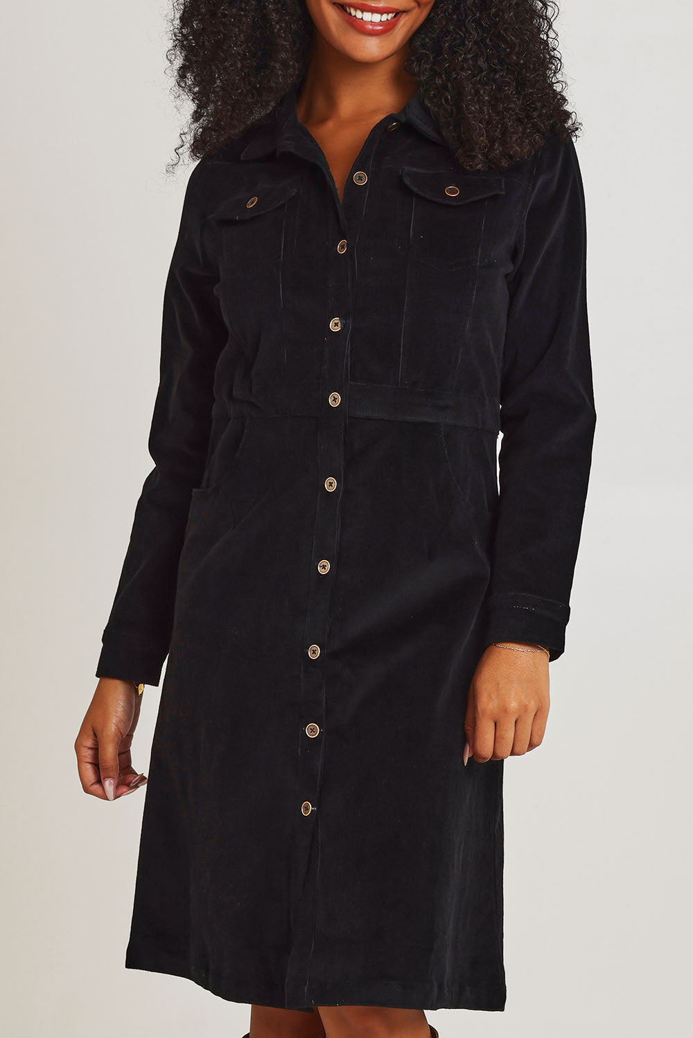 Model Ziara wearing size 10 of the Cotton Corduroy Button Dress in colour Black (Black), from the front, cropped image