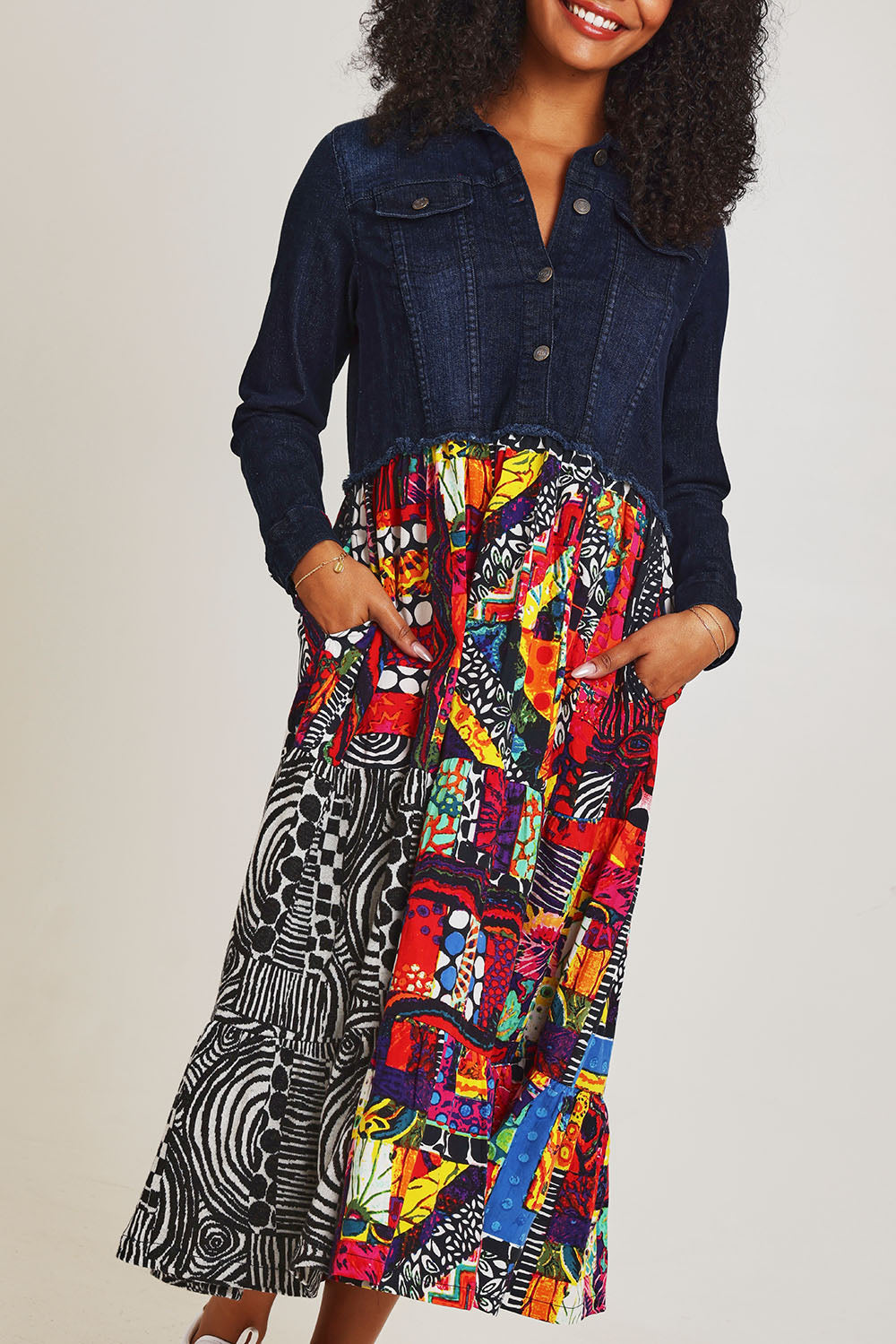 Model Ziara wearing size 10 of the Denim Mix Dress in colour Runaway, from the front, cropped image