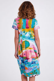 Model Emma wearing size 10 of the Printed Bubble Organic Cotton Dress in colour Dreamland (Blue), from the back
