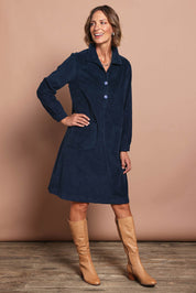 Model Riina wearing size 10 of the Cord Solids Pockets Dress in colour Navy (Blue), from the front, showing the whole outfit