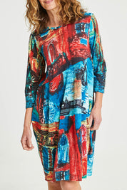 Model Emma wearing size 10 of the Cotton Bubble Dress in colour Venicemult (Blue), from the front, cropped image