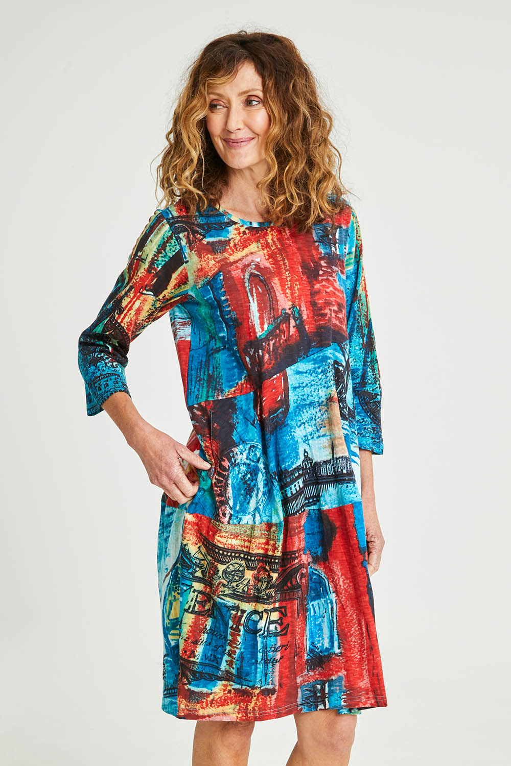 Model Emma wearing size 10 of the Cotton Bubble Dress in colour Venicemult (Blue), from the front, cropped image