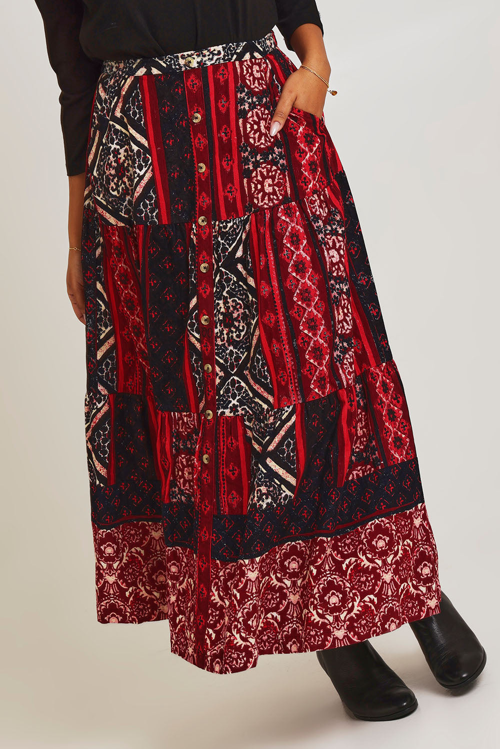 Model Ziara wearing size 10 of the Jolene Cord Skirt in colour Jolene (Red), from the front, cropped image