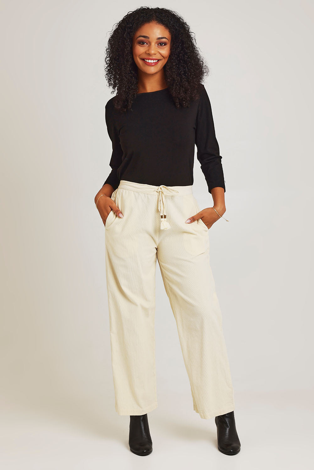 Model Ziara wearing size 10 of the Corduroy Flared Trouser in colour Ecru, from the front, showing the whole outfit