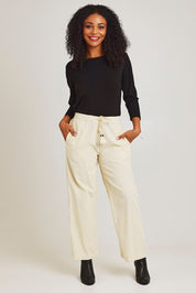 Model Ziara wearing size 10 of the Corduroy Flared Trouser in colour Ecru, from the front, showing the whole outfit