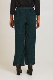 Model Ziara wearing size 10 of the Corduroy Flared Trouser in colour Pine (Green), from the back