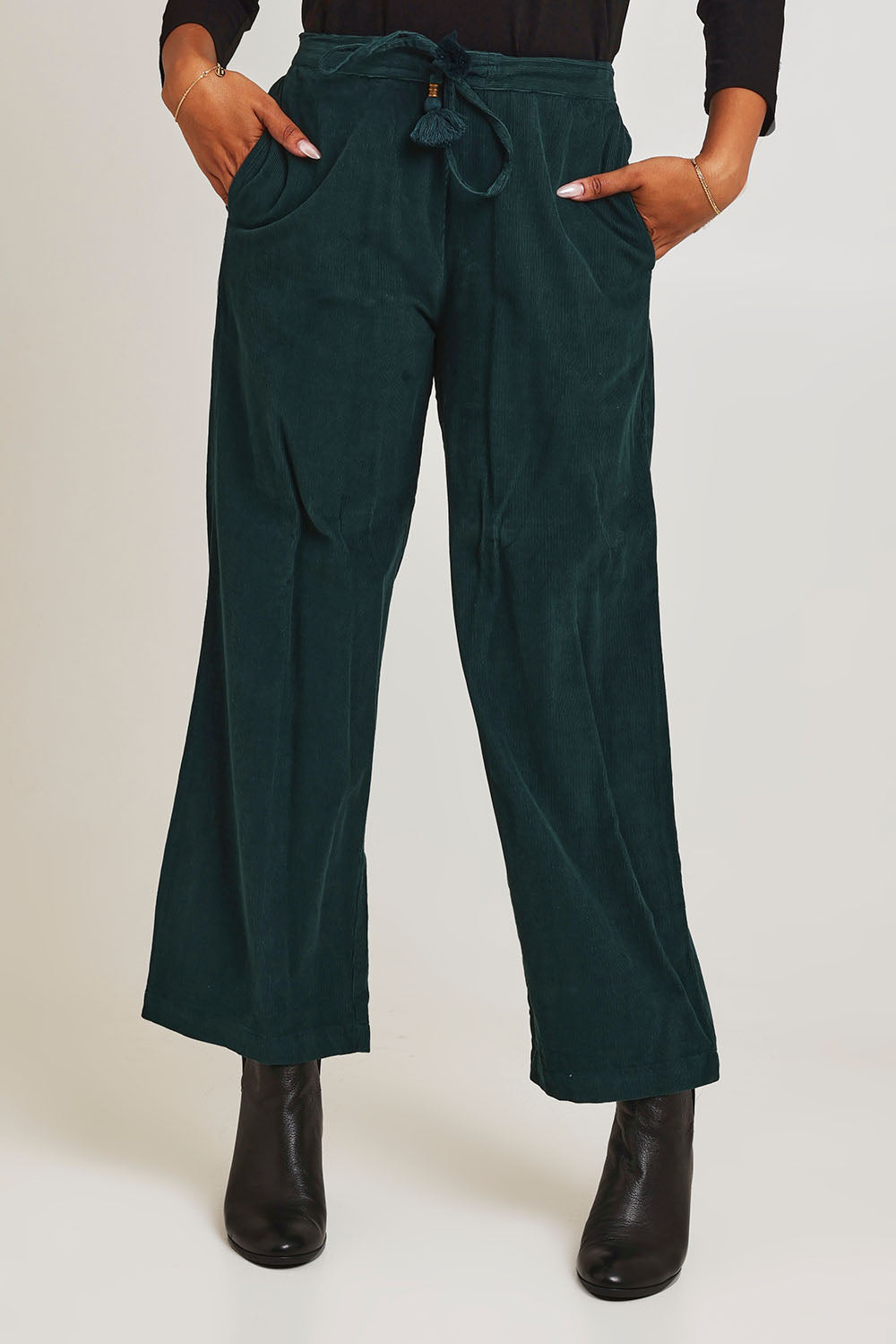 Model Ziara wearing size 10 of the Corduroy Flared Trouser in colour Pine (Green), from the front, cropped image