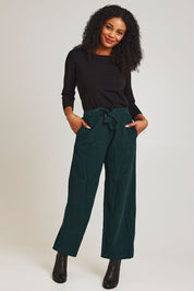 Model Ziara wearing size 10 of the Corduroy Flared Trouser in colour Pine (Green), from the front, showing the whole outfit