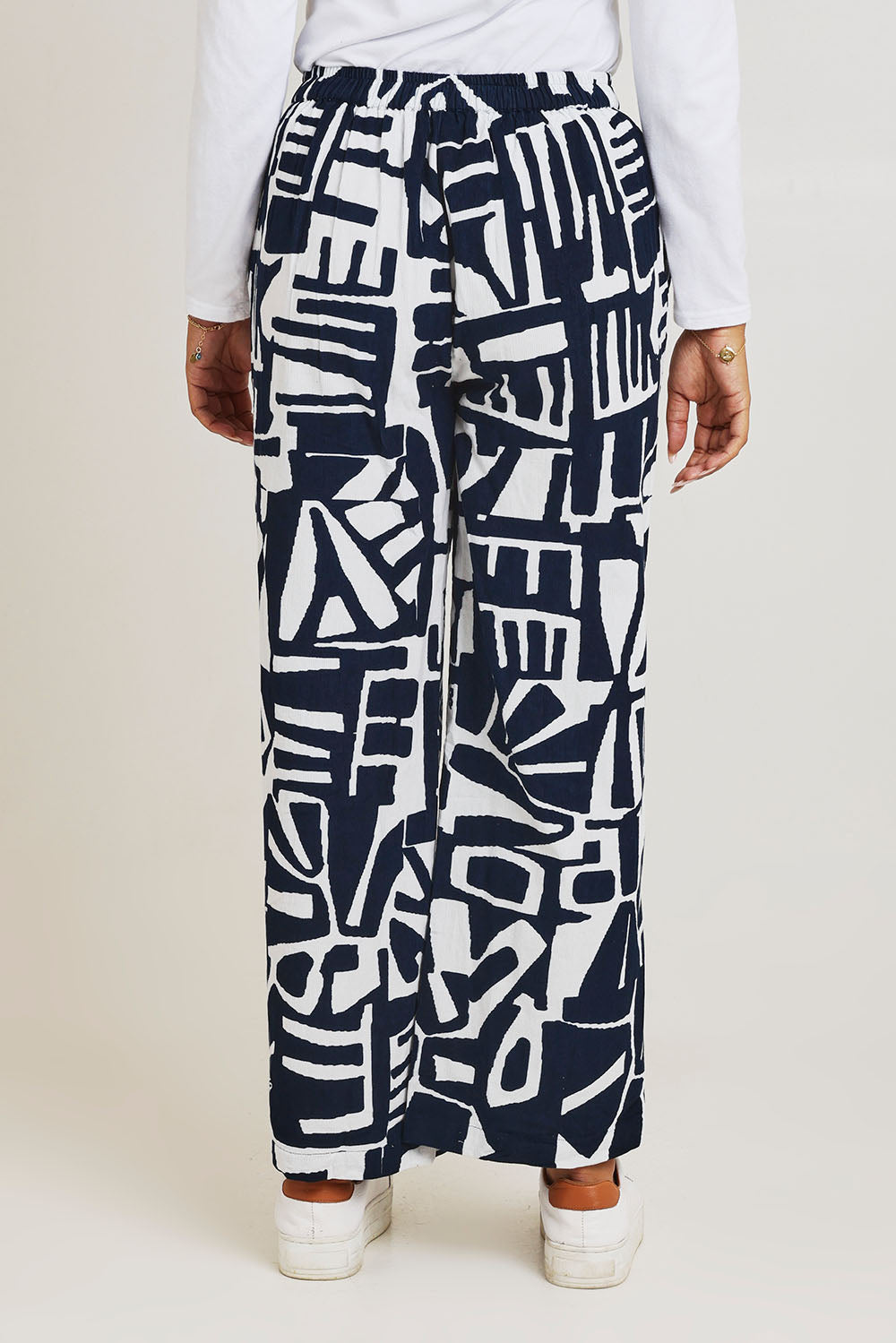 Model Ziara wearing size 10 of the Corduroy Flared Trouser in colour Navy (Blue), from the back