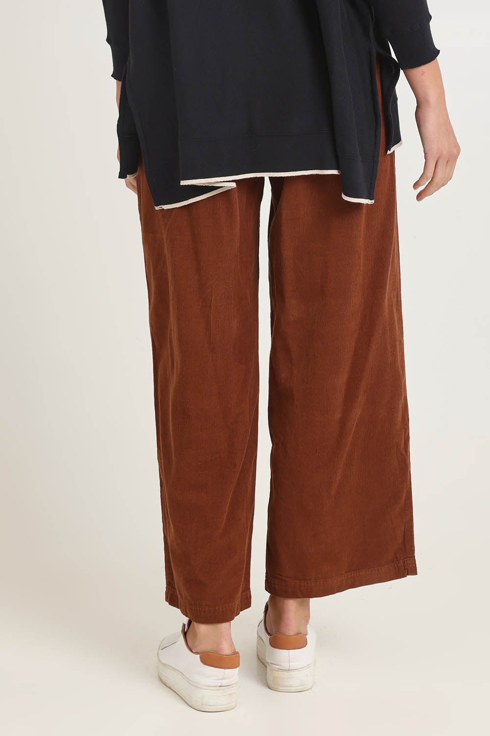 Model Madeline wearing size 10 of the Cord Solids Wide Leg Pant in colour Tan, from the back