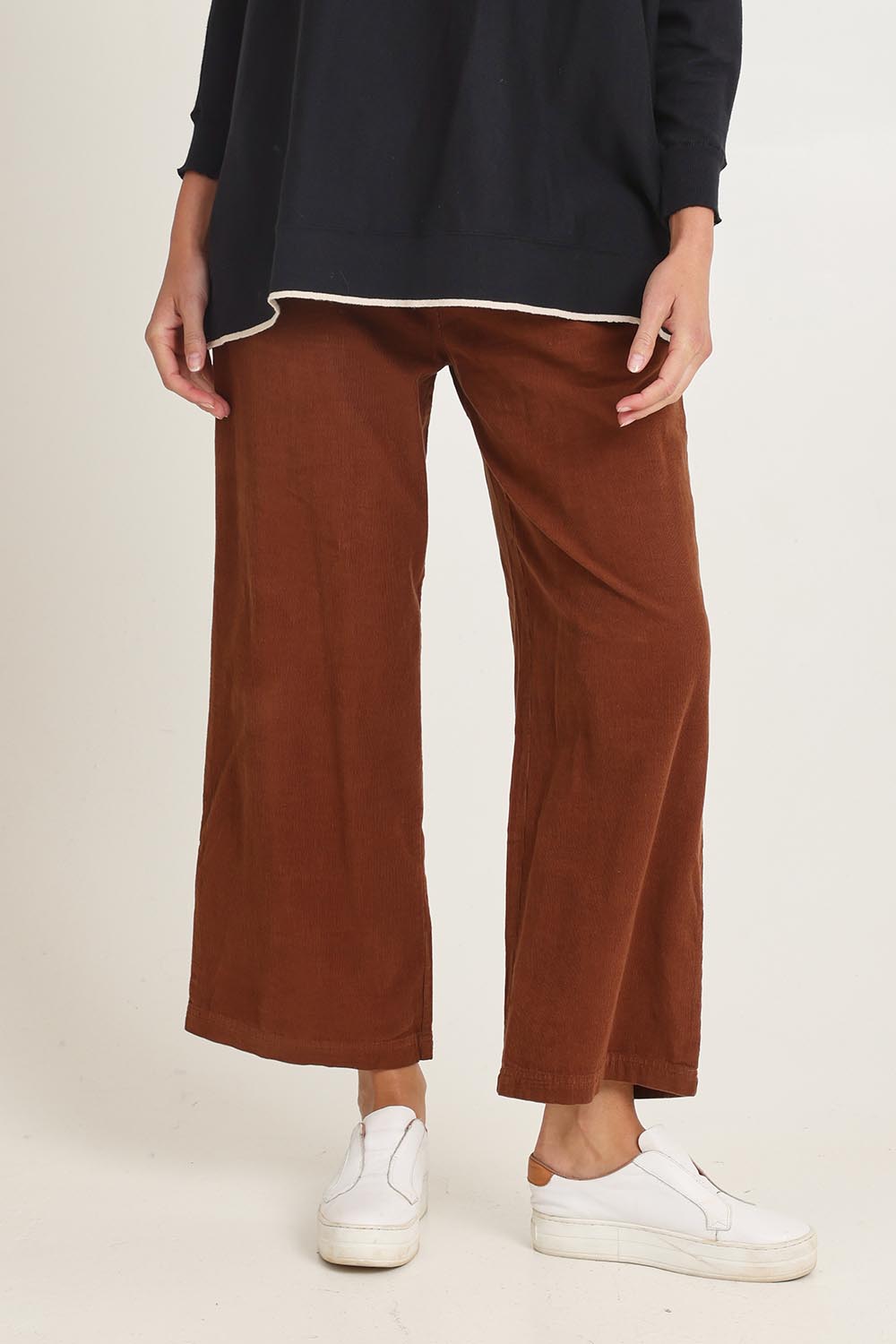 Model Madeline wearing size 10 of the Cord Solids Wide Leg Pant in colour Tan, from the front, cropped image