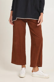 Model Madeline wearing size 10 of the Cord Solids Wide Leg Pant in colour Tan, from the front, cropped image