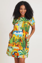 Model Ziara wearing size 10 of the Short Sleeve Reversible Cotton Dress in colour Guatemala, from the front, cropped image