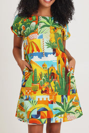 Model Ziara wearing size 10 of the Short Sleeve Reversible Cotton Dress in colour Guatemala, from the front, cropped image