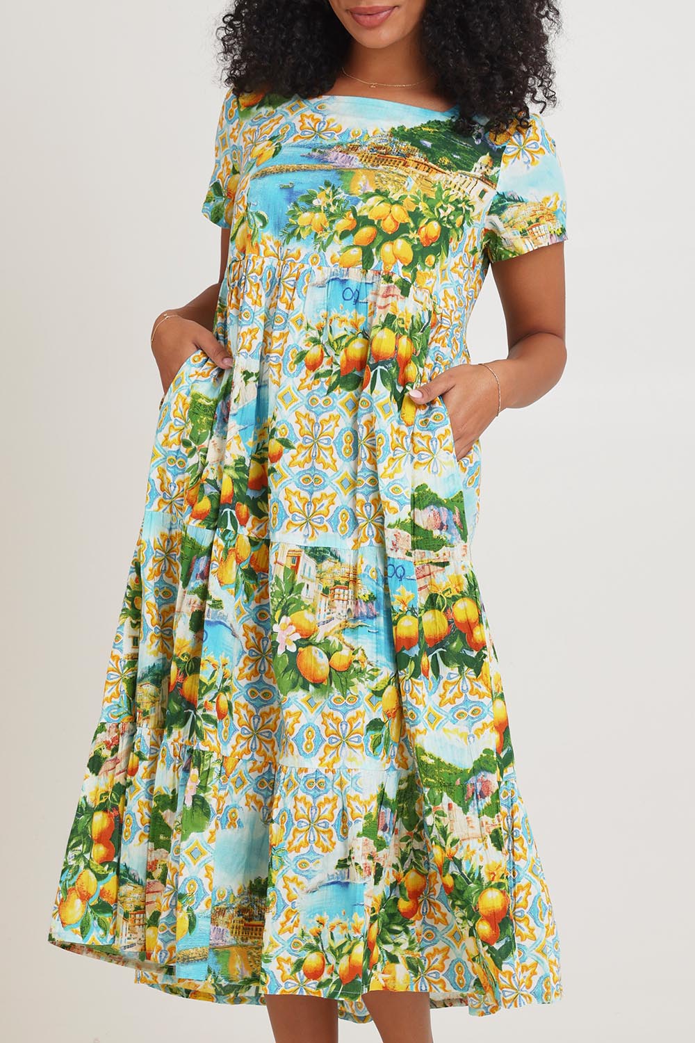 Model Ziara wearing size 10 of the Square Neckline Cotton Layers Dress in colour Amalfi, from the front, cropped image