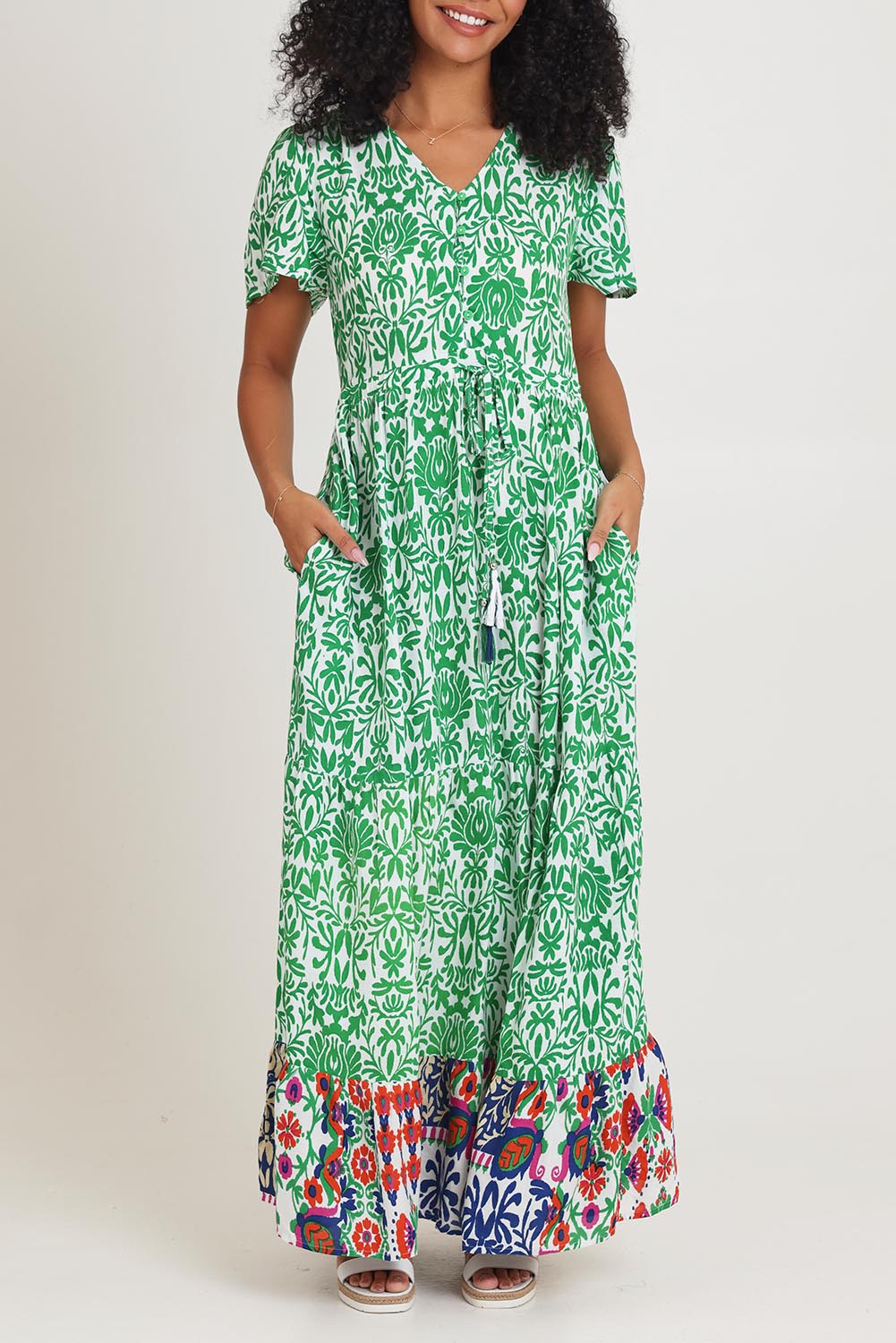 Model Ziara wearing size 10 of the Tie Waist Dress in colour Buzios (Green), from the front, cropped image