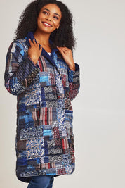 Model Ziara wearing size 10 of the Kantha Reversible Patch Puffer Coat in colour Kantha (Blue), from the front, cropped image