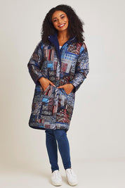 Model Ziara wearing size 10 of the Kantha Reversible Patch Puffer Coat in colour Kantha (Blue), from the front, showing the whole outfit