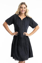 A model wearing the Essential Broderie Layers Cotton Dress in colour Black (Black), from the front, cropped image