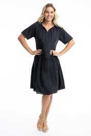 A model wearing the Essential Broderie Layers Cotton Dress in colour Black (Black), from the front, showing the whole outfit