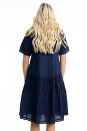 A model wearing the Essential Broderie Layers Cotton Dress in colour Navy (Blue), from the back