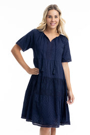 A model wearing the Essential Broderie Layers Cotton Dress in colour Navy (Blue), from the front, cropped image