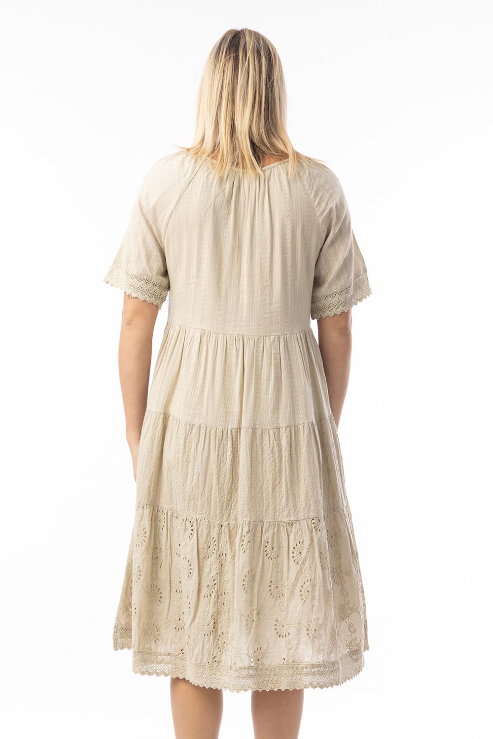 A model wearing the Essential Broderie Layers Cotton Dress in colour Sand, from the back