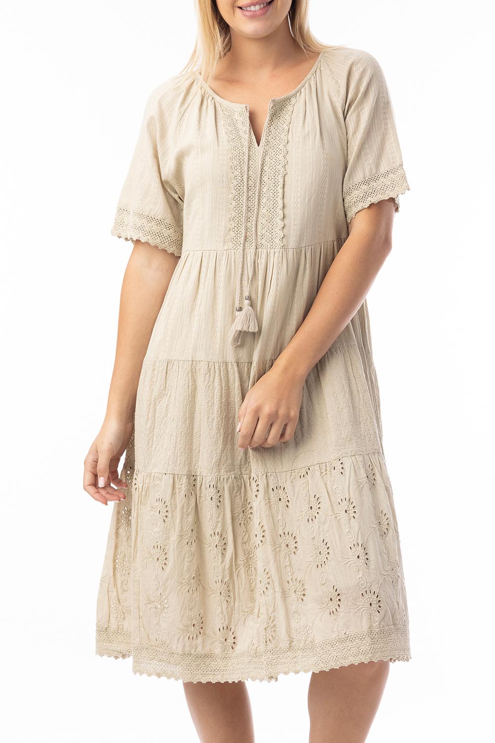 A model wearing the Essential Broderie Layers Cotton Dress in colour Sand, from the front, cropped image