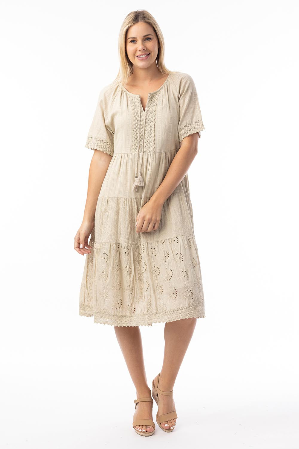 A model wearing the Essential Broderie Layers Cotton Dress in colour Sand, from the front, showing the whole outfit