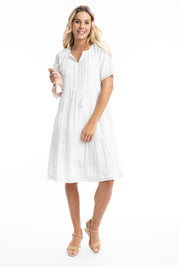 A model wearing the Essential Broderie Layers Cotton Dress in colour White (White), from the front, showing the whole outfit