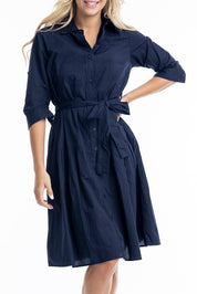 A model wearing the Essentials Organic Cotton Poplin Button through Belt dress in colour Navy (Blue), from the front, cropped image