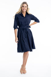 A model wearing the Essentials Organic Cotton Poplin Button through Belt dress in colour Navy (Blue), from the front, showing the whole outfit
