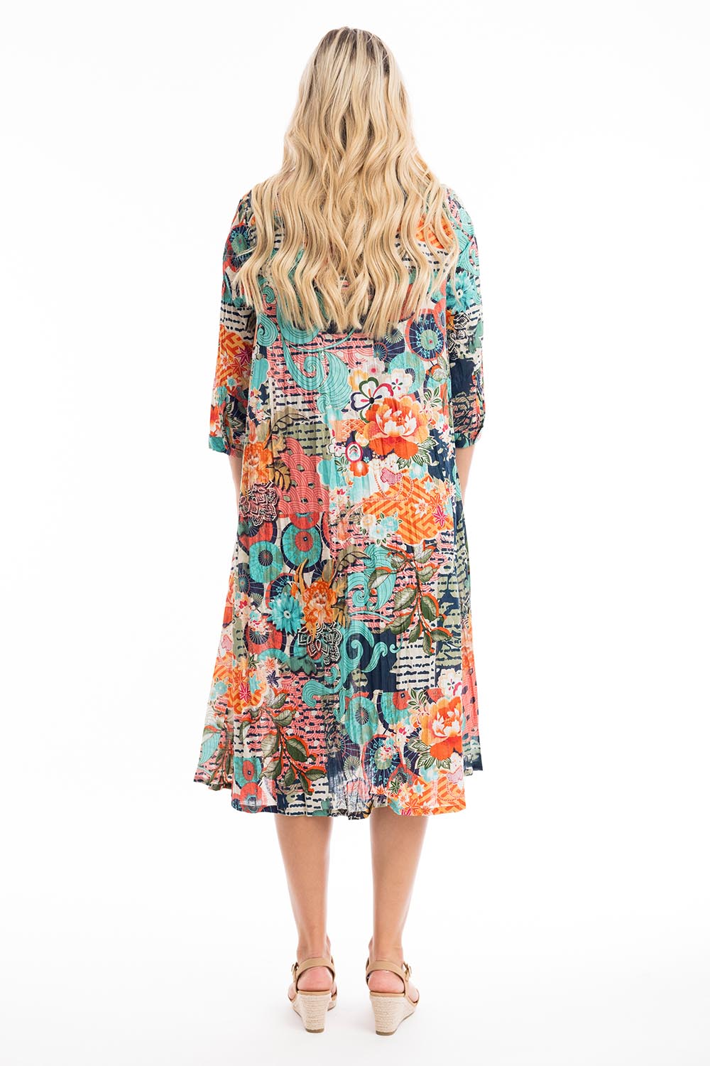 A model wearing the Yakushima Organic Cotton Patch Dress in colour Print (Blue), from the back