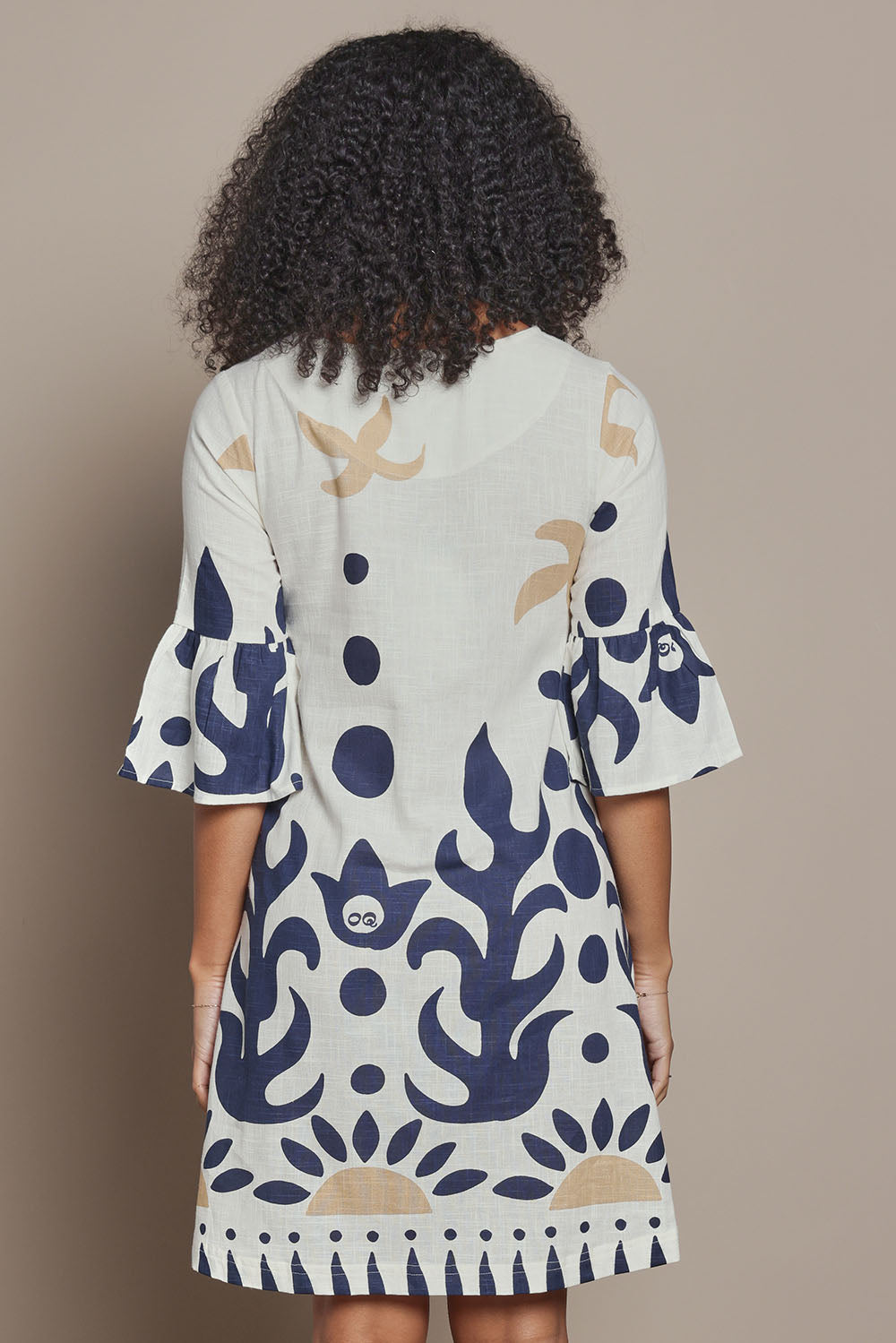 Model Ziara wearing size 10 of the Frill Sleeve Contemporary Cotton Dress in colour Nazca, from the back
