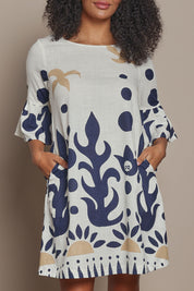 Model Ziara wearing size 10 of the Frill Sleeve Contemporary Cotton Dress in colour Nazca, from the front, cropped image