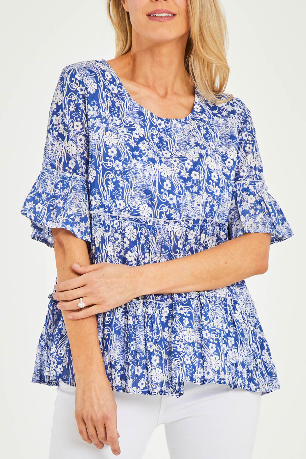Model Kelly wearing size 10 of the Cappadocia Organic Cotton Frill Sleeve Top in colour Blue (Blue), from the front, cropped image