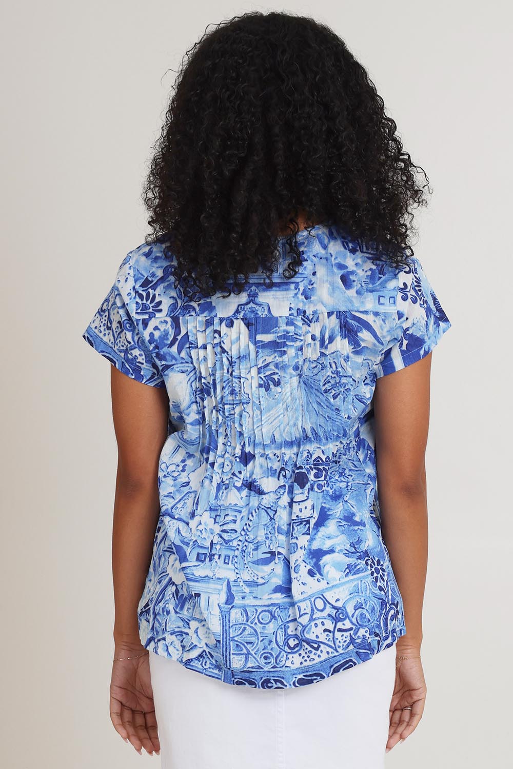 Model Ziara wearing size 10 of the Pleated Cotton Top in colour Okayama (Blue), from the back