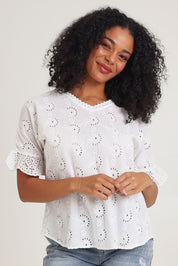 Model Ziara wearing size 10 of the Essentials Broderie Cotton Top in colour White (White), from the front, cropped image