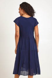 Model Pamelar wearing size 10 of the Essentials Bias Pockets Cotton Dress - Navy in colour Navy, from the back