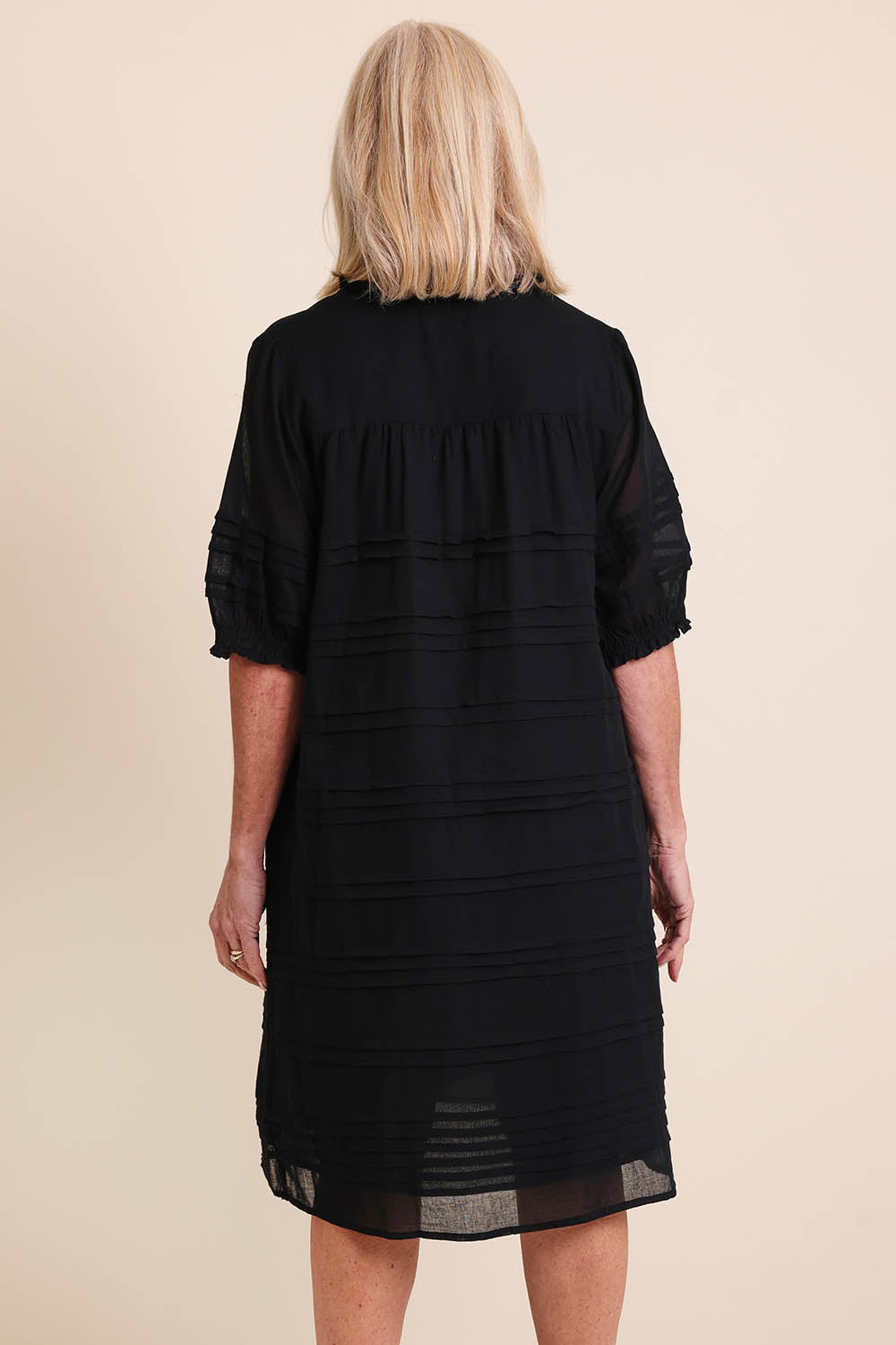 Model Sandys wearing size 10 of the Essentials Pleated Cotton Dress - Black in colour Black, from the back