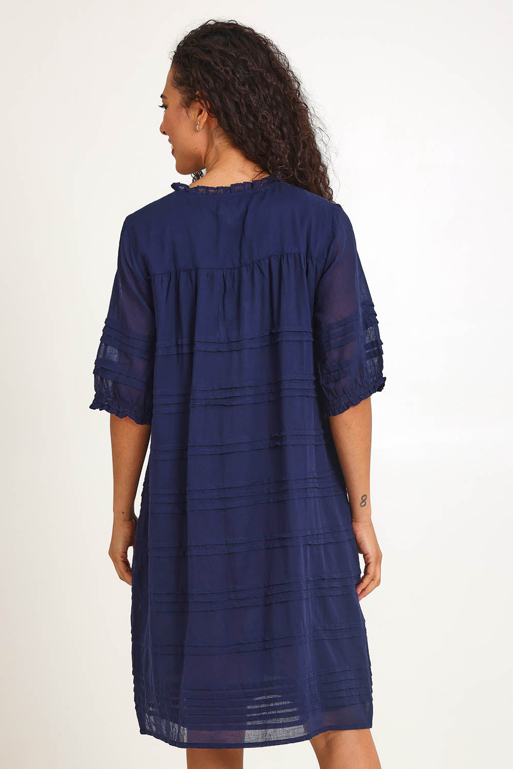 Model Pamelar wearing size 10 of the Essentials Pleated Cotton Dress - Navy in colour Navy, from the back