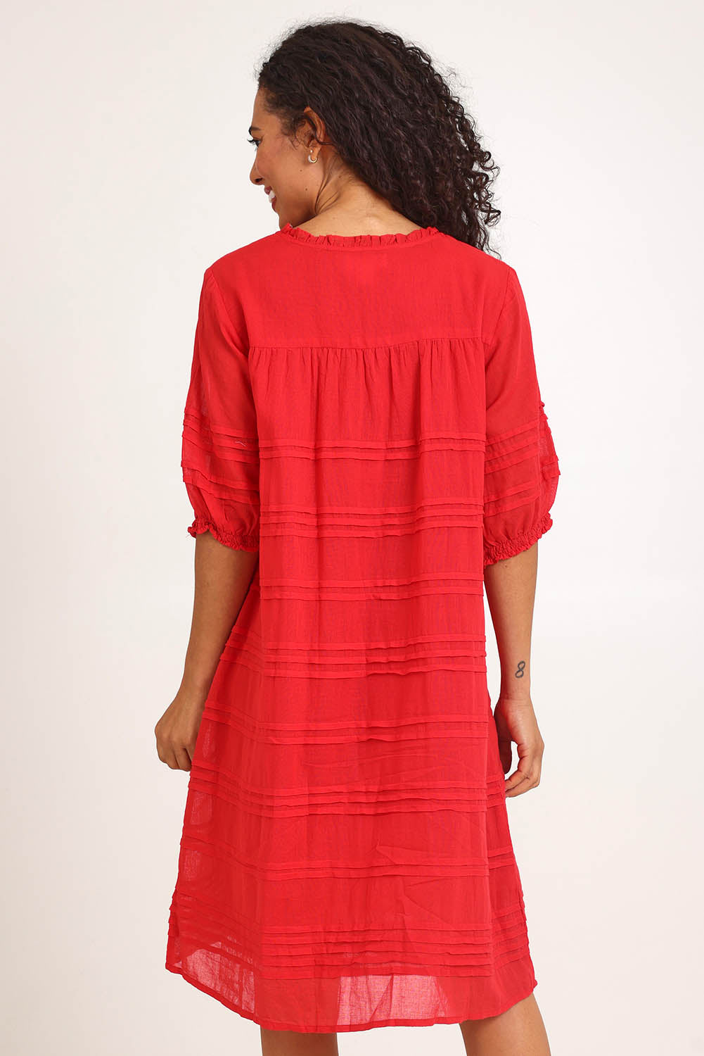 Model Pamelar wearing size 10 of the Essentials Pleated Cotton Dress - Red in colour Red, from the back