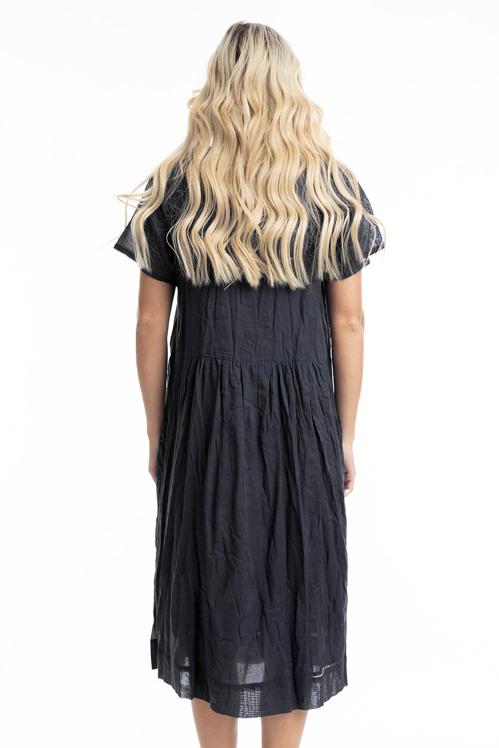 A model wearing the Essentials Organic Cotton Gauze Peak Dress in colour Black (Black), from the back