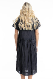 A model wearing the Essentials Organic Cotton Gauze Peak Dress in colour Black (Black), from the back